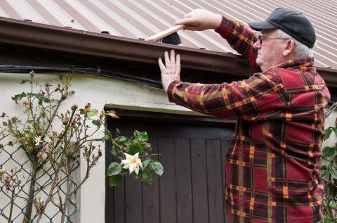 homme nettoyant sa gouttière